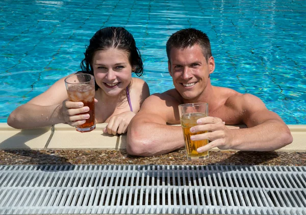 Met een drankje in de sund bij zwembad (echt) paar — Stockfoto