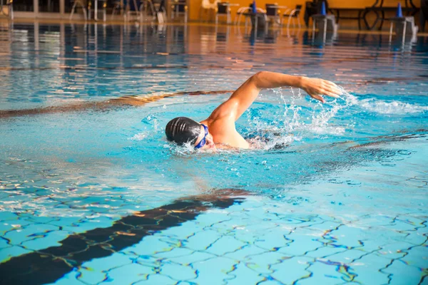 Man swims front crawl style in swimming pool — Stock Photo, Image