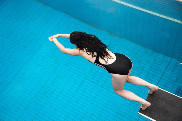 Žena skáče z odrazovým můstkem na bazén — Stock fotografie