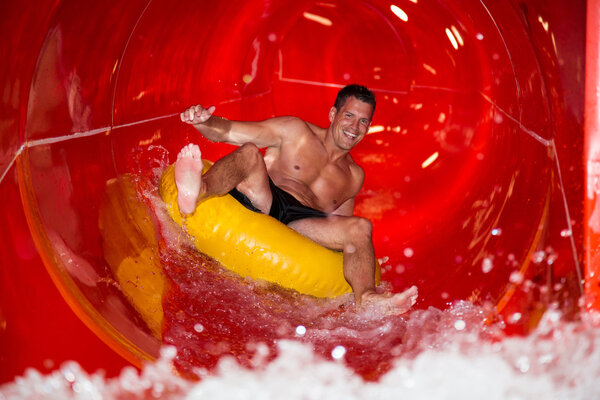 Couple in water slide at public swimming pool