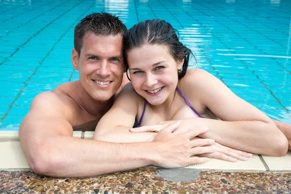 Casal em férias posando na borda da piscina do hotel — Fotografia de Stock