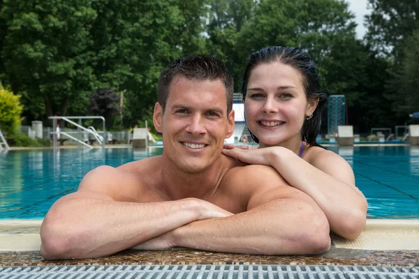 Casal desfrutando de férias na borda da piscina — Fotografia de Stock