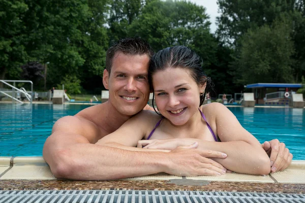 Casal desfrutando de férias na borda da piscina — Fotografia de Stock