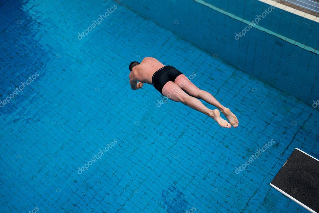 Man jumps from diving board at swimming pool — Stock Photo © Ikonoklast