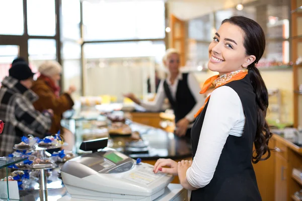 Salesperson at cash register — Stock Photo, Image