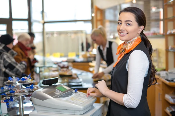 Comerciante e vendedora na caixa registradora ou mesa de caixa — Fotografia de Stock