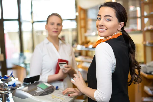 Client at shop paying at cash register — Stock Photo, Image