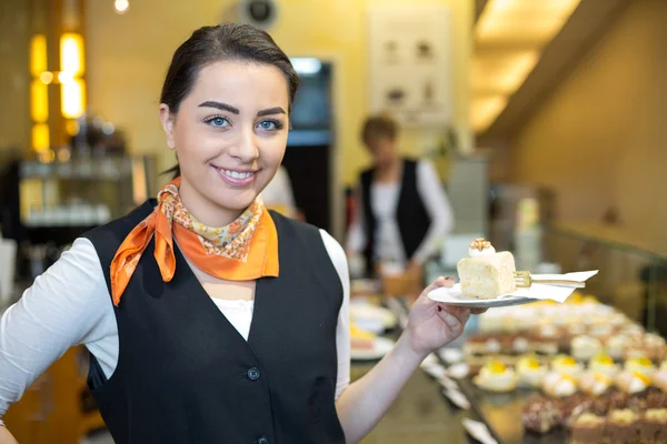 Waitress presenting cake in cafe or confectionery — Stock Photo, Image
