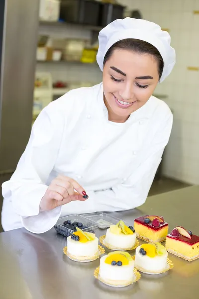 Confectioner preparing cakes at bakery or confectionery — Stock Photo, Image