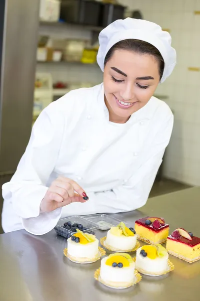 Banketbakker voorbereiding koeken tijdens bakkerij of suikerwerk — Stockfoto