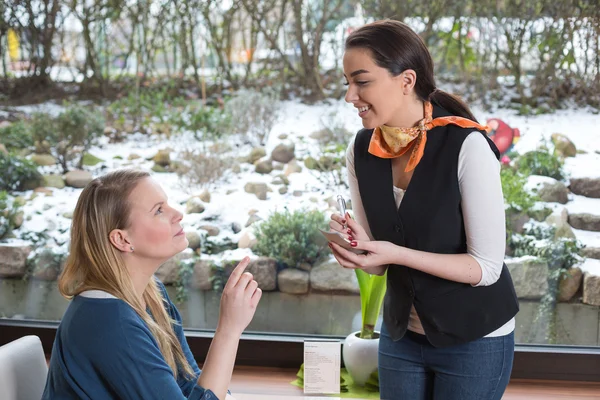 Servitrisen som betjänar en kund i restaurang eller café — Stockfoto