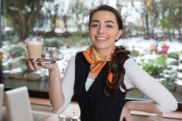 Servírka pózuje s šálkem kávy v kavárně nebo v restauraci — Stock fotografie