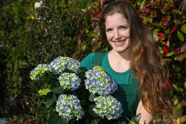 Kvinna poserar med hortensia blomma — Stockfoto