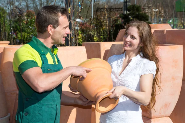 Employee in garden center selling pottery to customer — Stock Photo, Image