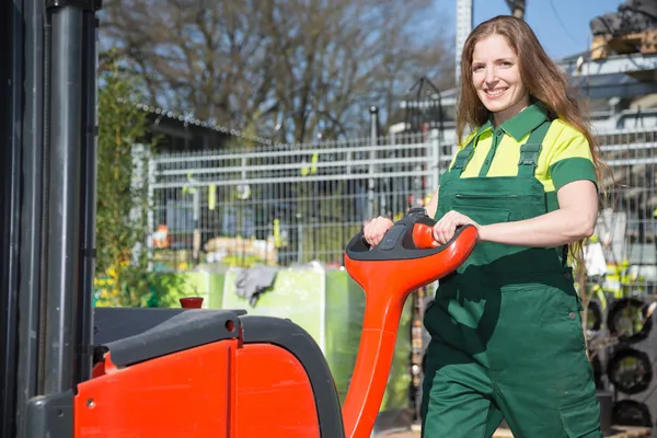 Werknemer met heftruck in het magazijn of opslagplaats — Stockfoto