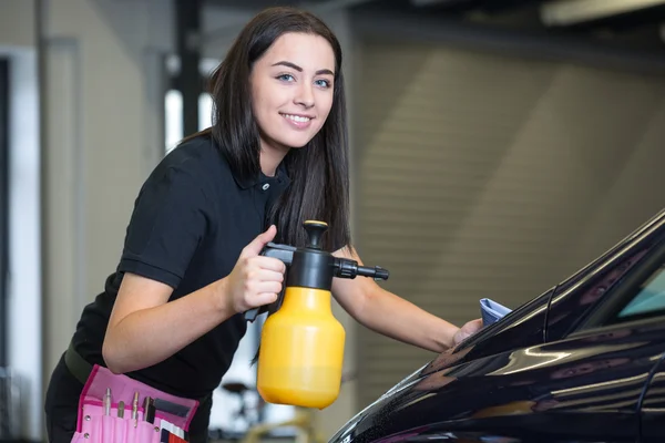 Worker cleaning car with cloth and spray bottle — Stock Photo, Image