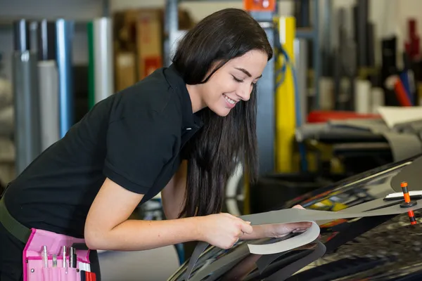 Trabajador en el taller de envoltura de automóviles pega papel de aluminio al coche —  Fotos de Stock