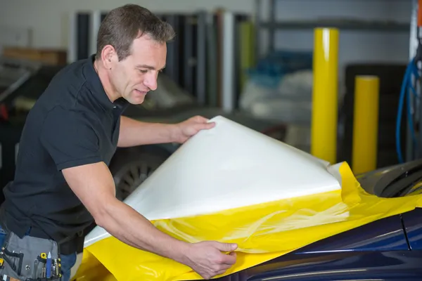 Empacotador de carro preparando folha para embrulhar um veículo — Fotografia de Stock