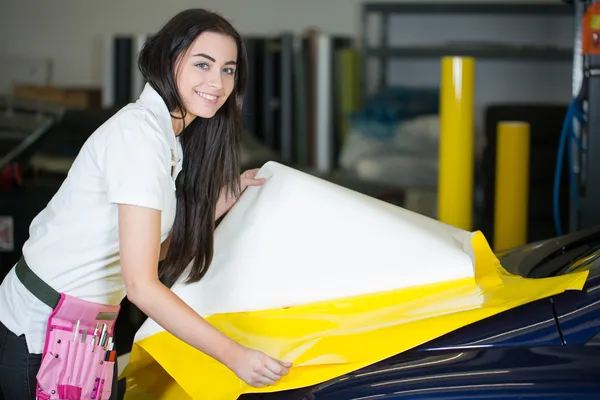 Car wrapper preparing foil to wrap a vehicle — Stock Photo, Image