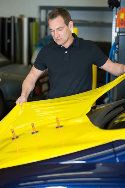 Car wrapper wrapping car with yellow vinyl foil — Stock Photo, Image