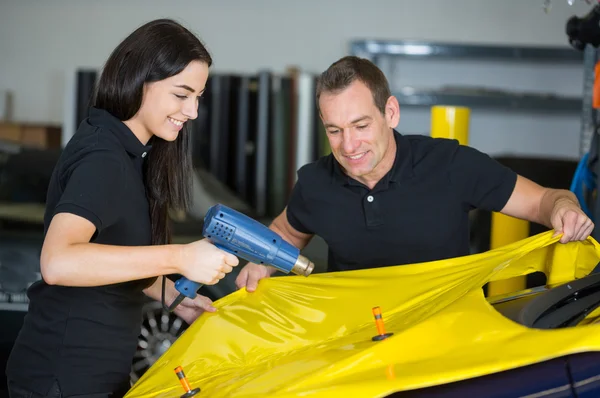 Car wrappers using heat gun to prepare vinyl foil — Stock Photo, Image