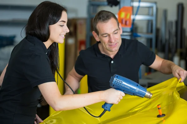 Auto wrappers met behulp van warmte pistool te bereiden vinyl folie — Stockfoto