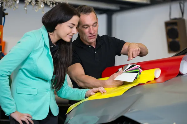 Car wrapping specialist consulting client about vinyl films — Stock Photo, Image
