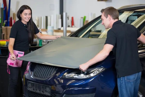 Car wrappers wrapping vehicle with vinyl film or foil — Stock Photo, Image