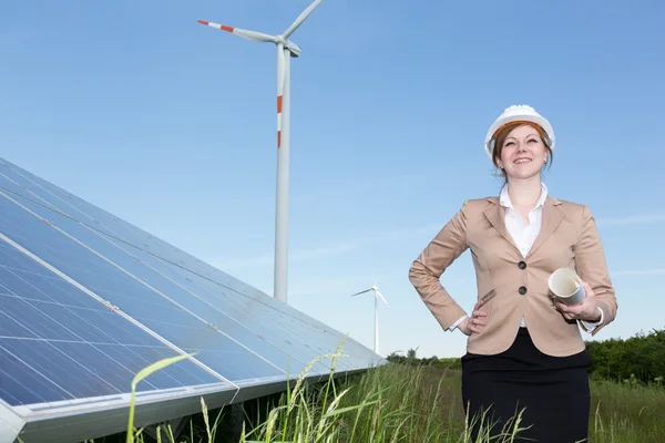 Ingénieur posant avec éolienne et panneaux solaires — Photo