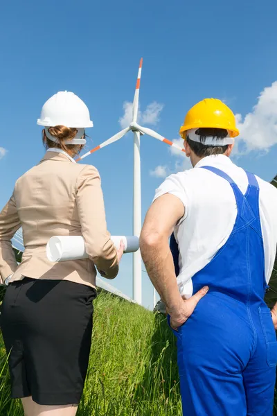 Ingénieur et entrepreneur posant devant une éolienne — Photo