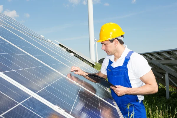 Ingeniero inspecciona los paneles solares en el parque de energía — 图库照片