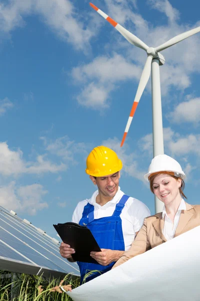 Dois engenheiros olham para o plano de construção de painéis solares — Fotografia de Stock