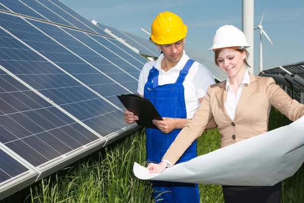 Dos ingenieros miran el plan de construcción de paneles solares — Foto de Stock