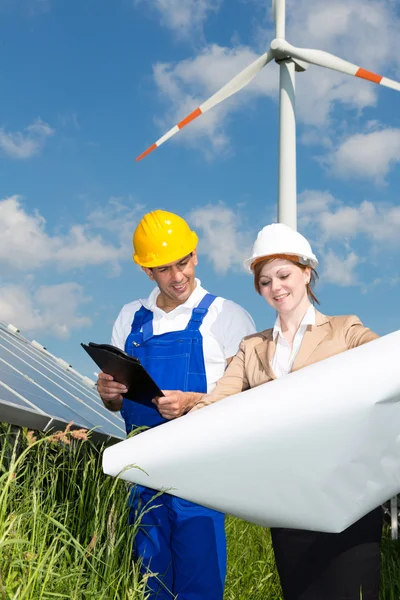 Two engineers look at construction plan of solar panels — Stock Photo, Image