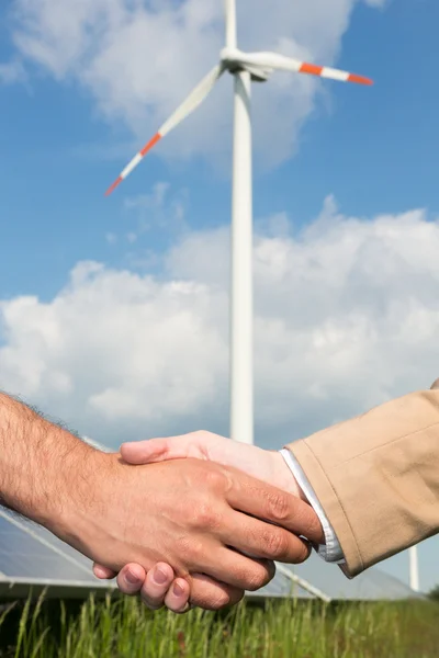 Handshake před větrnou turbínu a modrá obloha — Stock fotografie