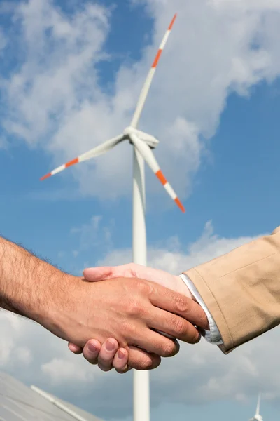 Handshake před větrnou turbínu a modrá obloha — Stock fotografie