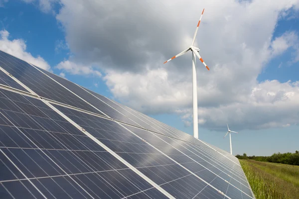 Вітрові турбіни з сонячними панелями в енергетичному парку — стокове фото