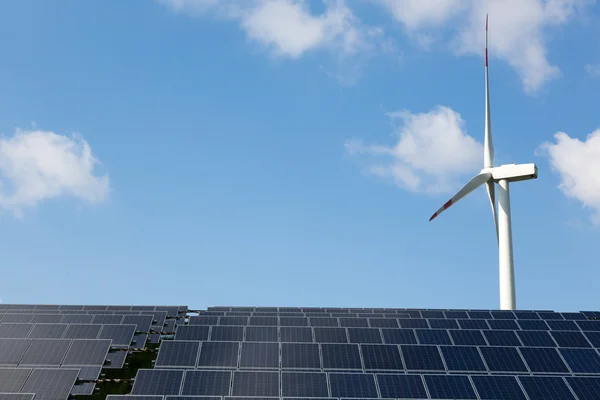 Wind energy turbine with some solar panels for electricity production — Stock Photo, Image