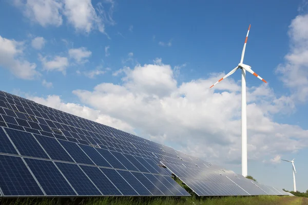 Wind energy turbine with some solar panels for electricity production — Stock Photo, Image