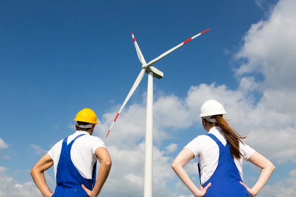 Engenheiros ou instaladores posando na frente da turbina de energia eólica — Fotografia de Stock