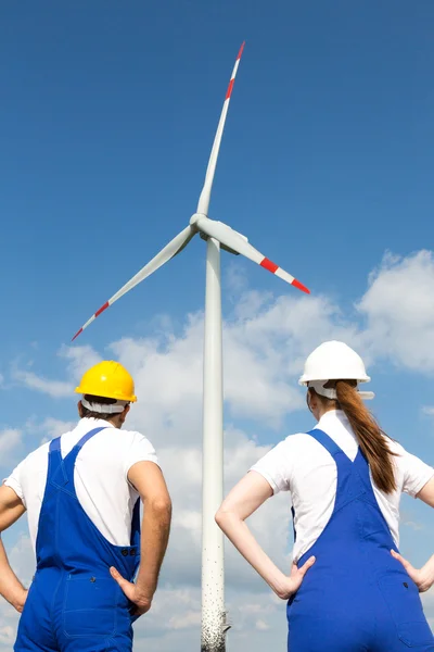 Інженери або установники, які позують перед вітроенергетичними турбінами — стокове фото