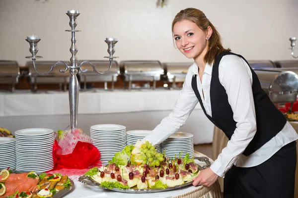 Catering service employee or waitress preparing a buffet — Stock Photo, Image