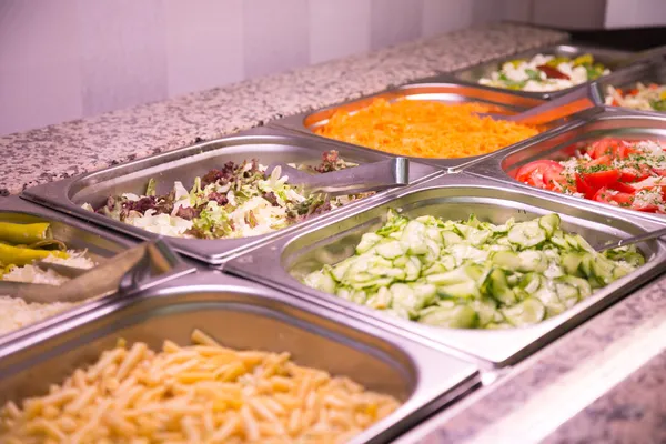 Salad, carrots and cucumbers on buffet at restaurant — Stock Photo, Image