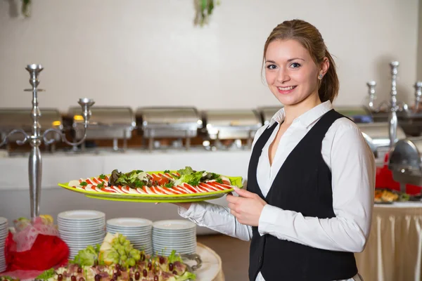 Catering dienst werknemer poseren met lade voor buffett — Stockfoto