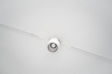 Halojen lambalı asma tavan ve boş bir oda ya da evde alçıpan inşaatı. Gergin tavan beyaz ve karmaşık şekil.