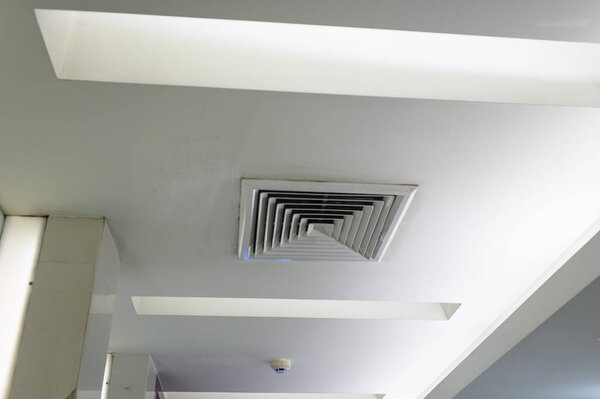 Ceiling mounted cassette type air conditioner, interior of a modern building.