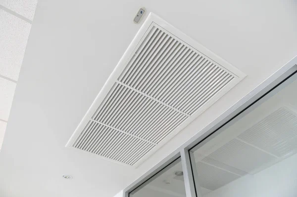 Ceiling mounted cassette type air conditioner and modern lamp light on white ceiling. duct air conditioner for home or office