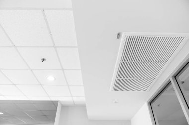 Ceiling mounted cassette type air conditioner and modern lamp light on white ceiling. duct air conditioner for home or office
