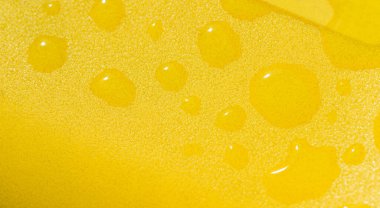 Su damlasıyla sarı plastik dokuyu kapat. Metin için boş alan.