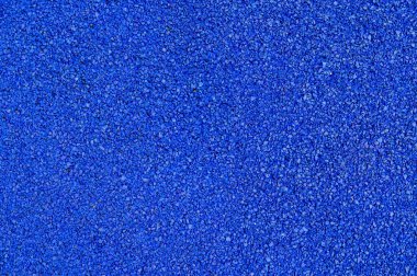 Plastik yumuşak kaplama dokusuna yakın çekim. Spor stadyumunda kullanılan yüzey, koşu pisti, koşu bandı, çocuk parkı. Geri dönüşümlü lastiklerden yapılmış modern zemin tanecikleri..